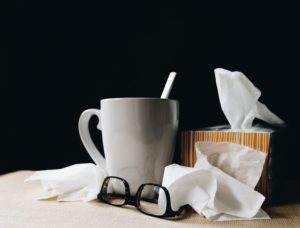 cup of tea, tissues, glasses on a table top